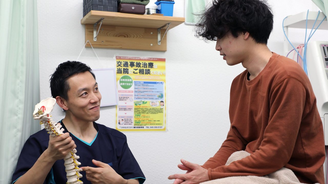 かみなかひかり鍼灸院接骨院の光本院長が、模型を使って患者に説明している様子